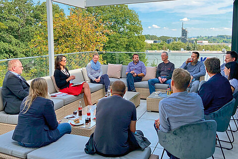 Natalie Mekelburger im Austausch mit mehreren Mitarbeitenden im Rahmen der sogenannten Terrassengespräche