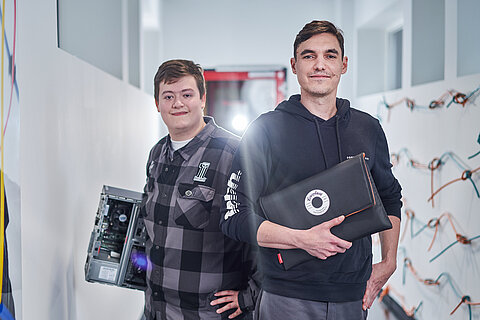 Photo of two Coroplast Group employees with a CoroUpcycling laptop bag.