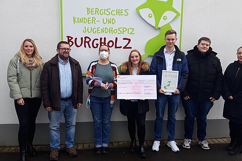 The apprentices hand over a donation check to the Bergisches Kinder- und Jugendhospiz
