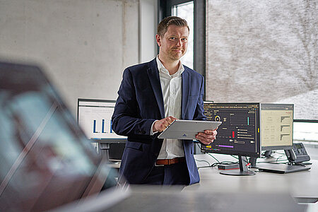 [Translate to Deutsch:] Mitarbeiter an seinem Arbeitsplatz