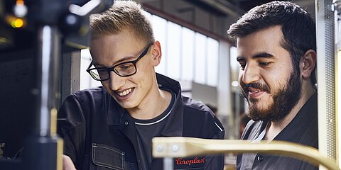 Zwei junge Mitarbeiter bei der Kabelproduktion