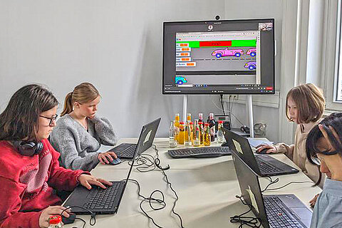 Vier Mädchen beim Entwickeln von Funktionen für das Programm „Scratch“